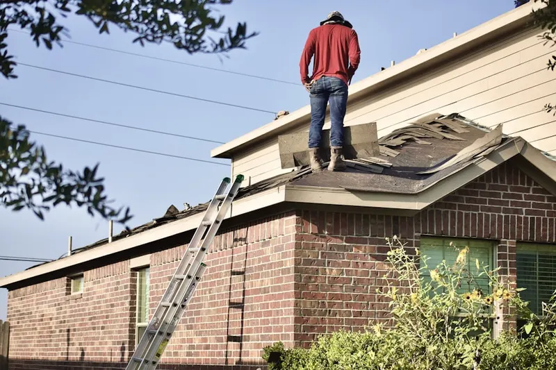 Professional roofer working on a residential roof in Colony North